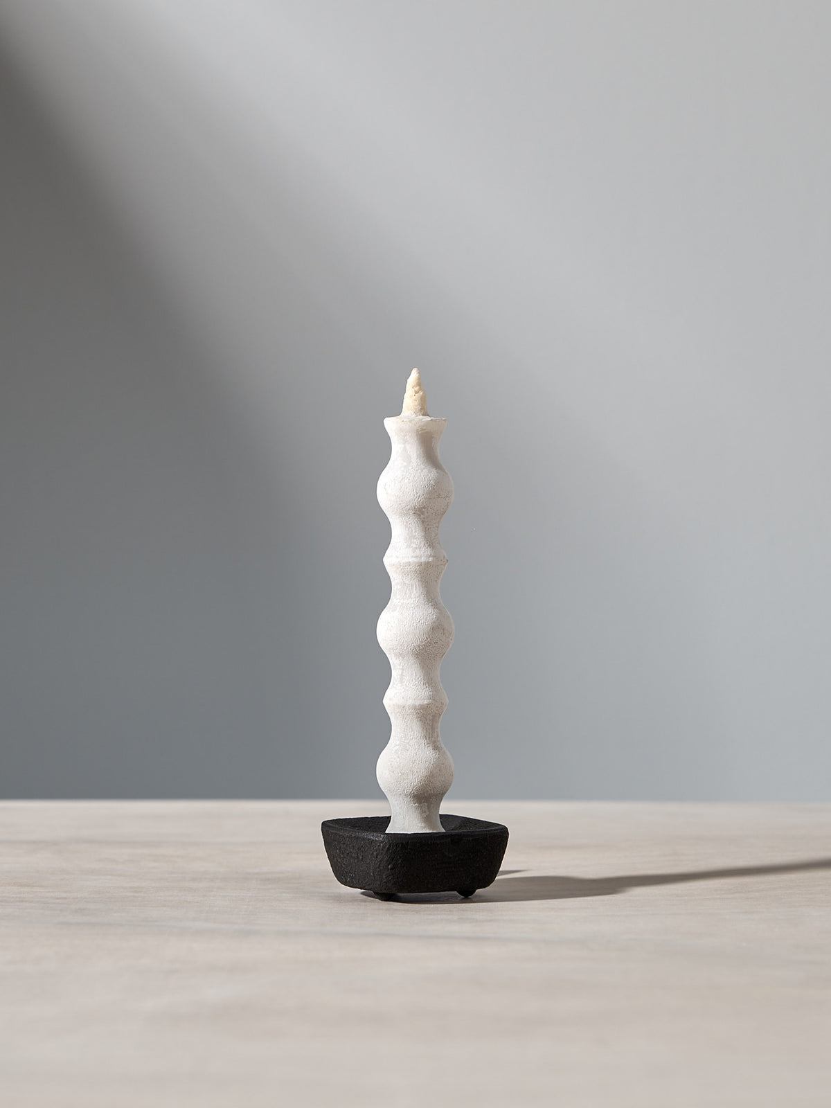 A NANAO – 5 Piece Mixed Box Set candle by Takazawa is sitting on a table with a light behind it.