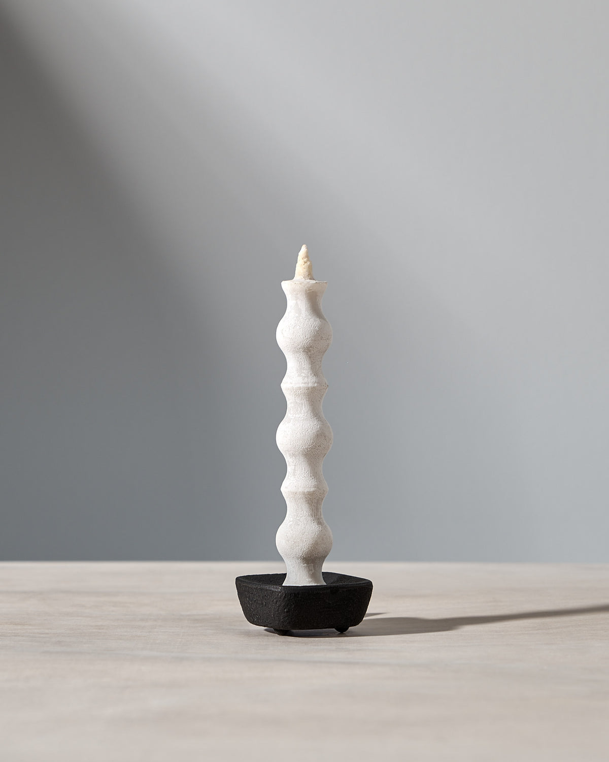 A NANAO – 5 Piece Mixed Box Set candle by Takazawa is sitting on a table with a light behind it.