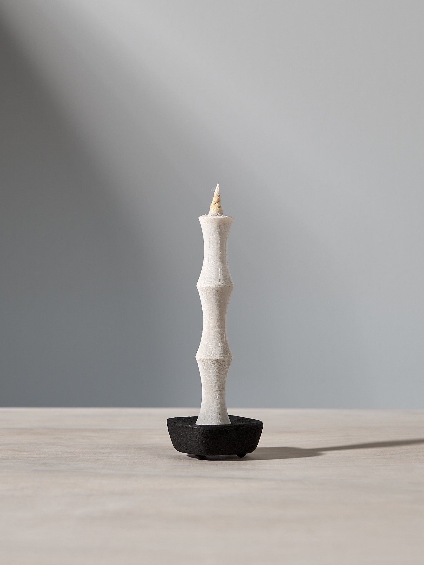 A NANAO-N candle sitting on top of a Takazawa wooden table.