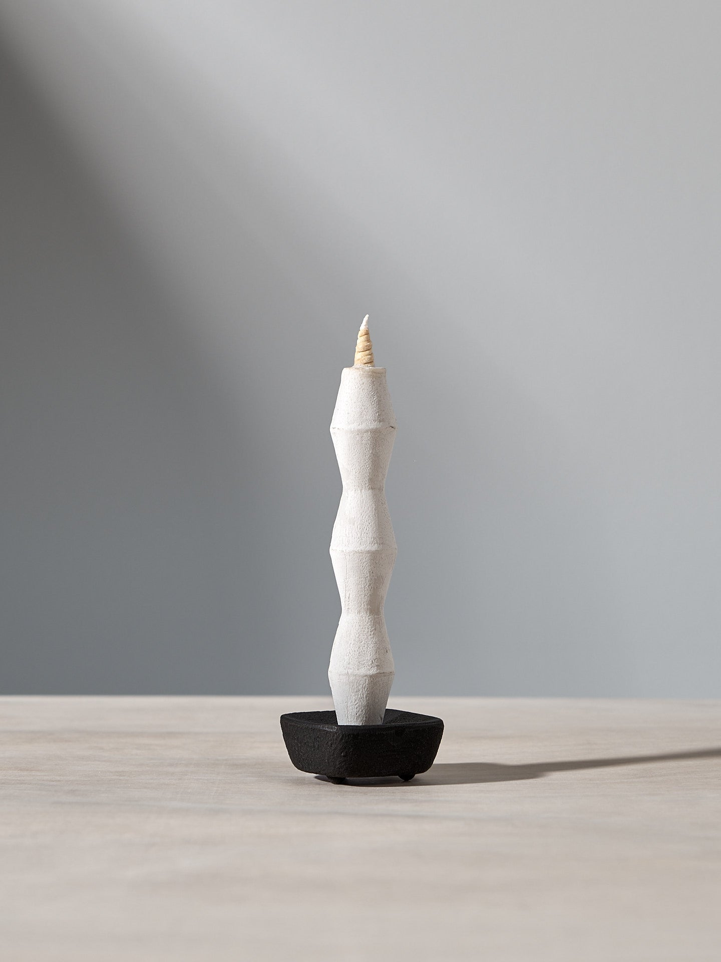 A NANAO-P candle sitting on top of a Takazawa wooden table.
