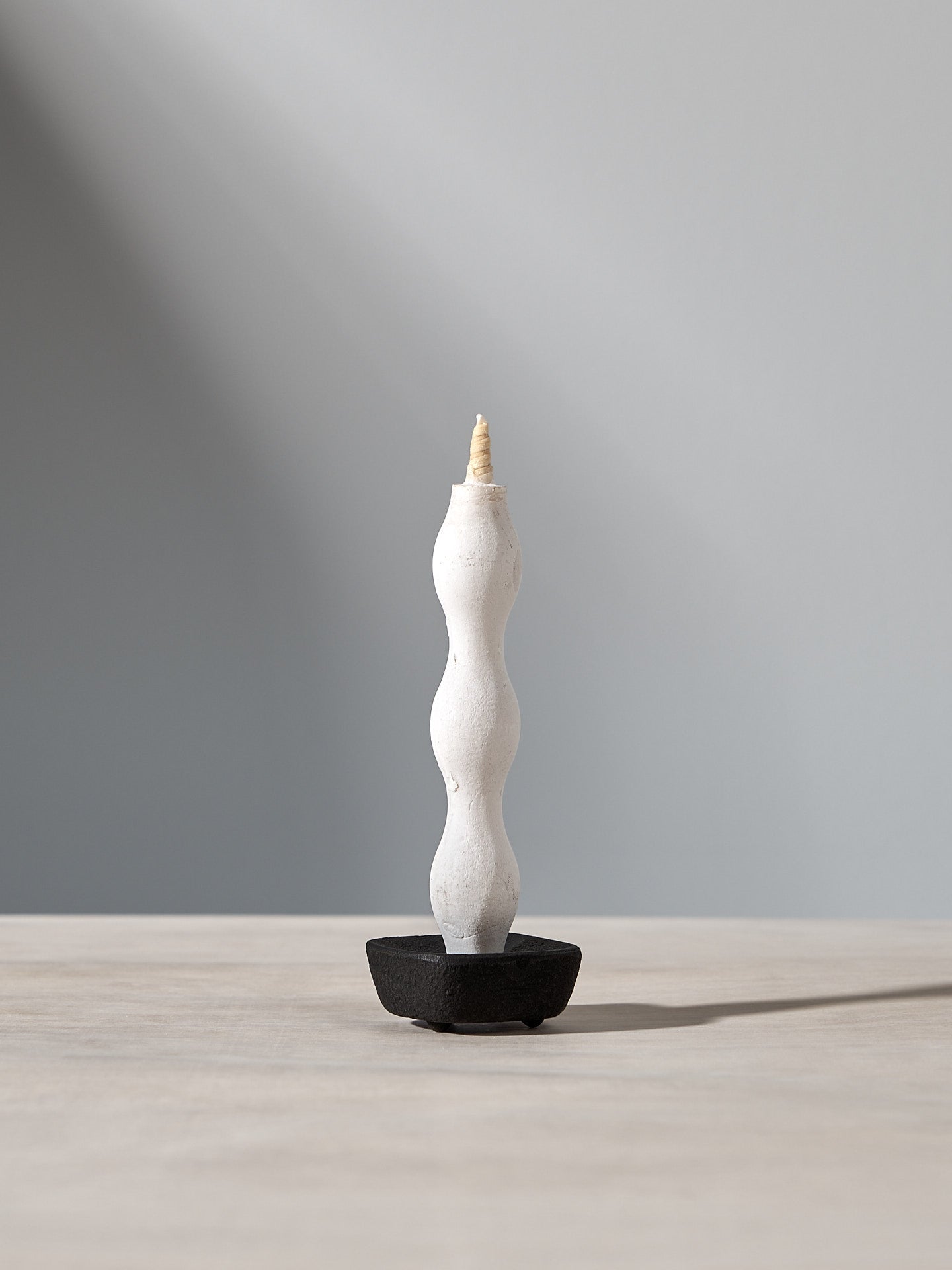 A NANAO-T candle sitting on top of a wooden table by Takazawa.