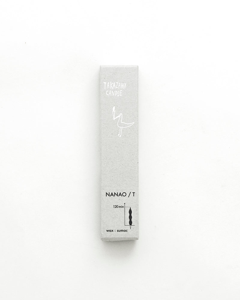 A NANAO-P candle sitting on top of a Takazawa wooden table.