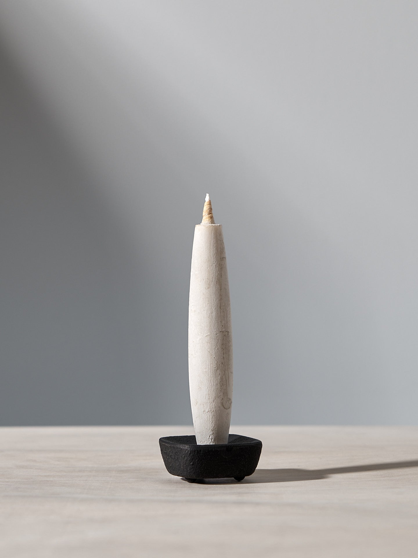 A TOHAKU candle sitting on top of a wooden table.