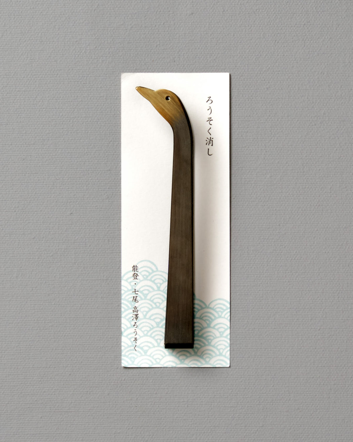 A Takazawa Candle Snuffer Duck with a wooden bird on it.