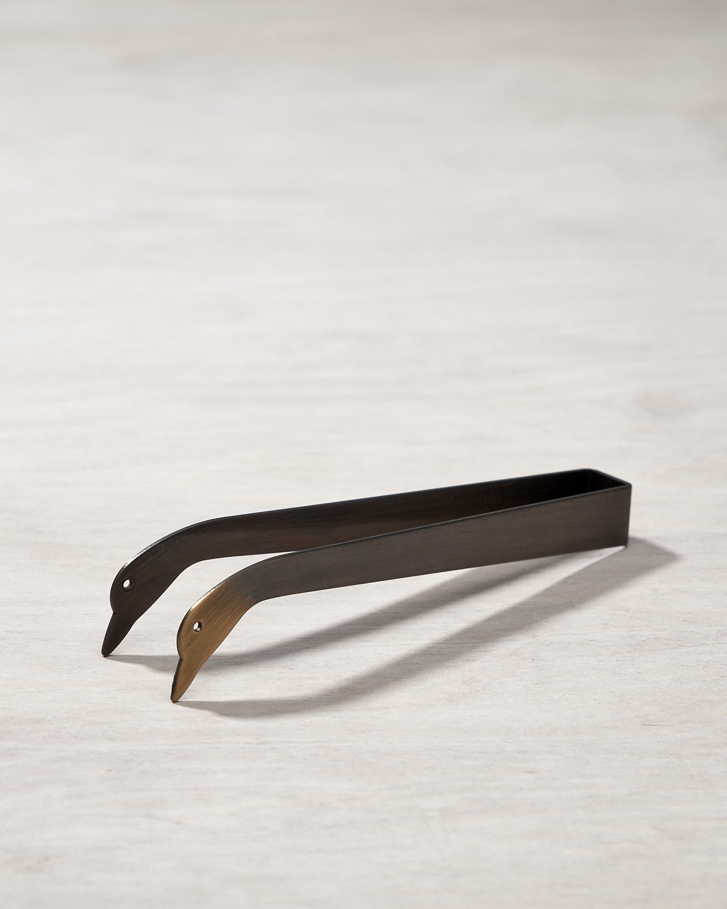 A pair of Candle Snuffer Ducks by Takazawa on a wooden surface.