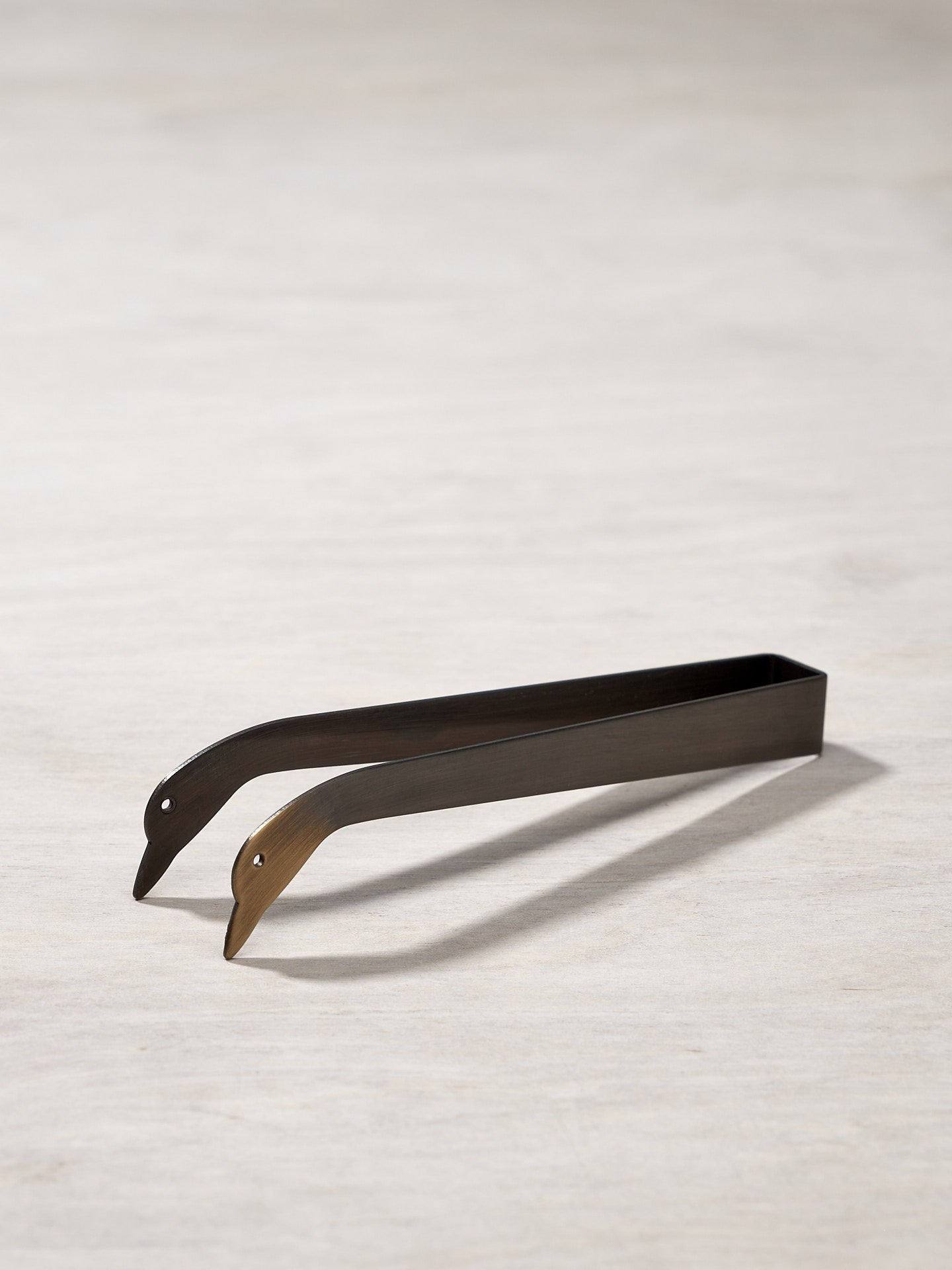 A pair of Candle Snuffer Ducks by Takazawa on a wooden surface.