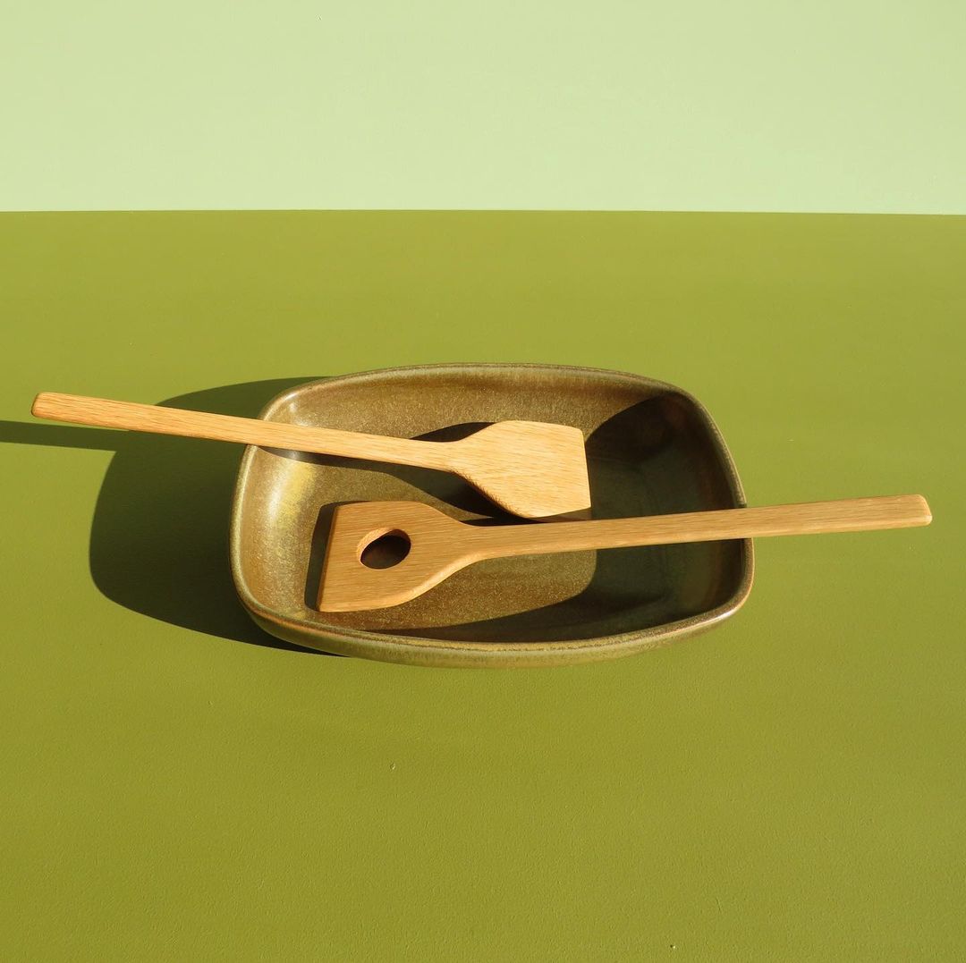 Two River wooden spoon servers on a green plate.