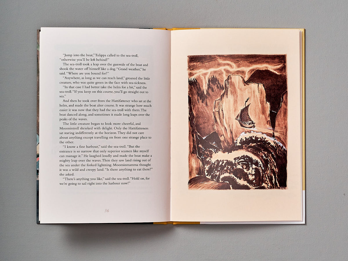 An open book with a picture of The Moomins and the Great Flood by Tove Jansson.