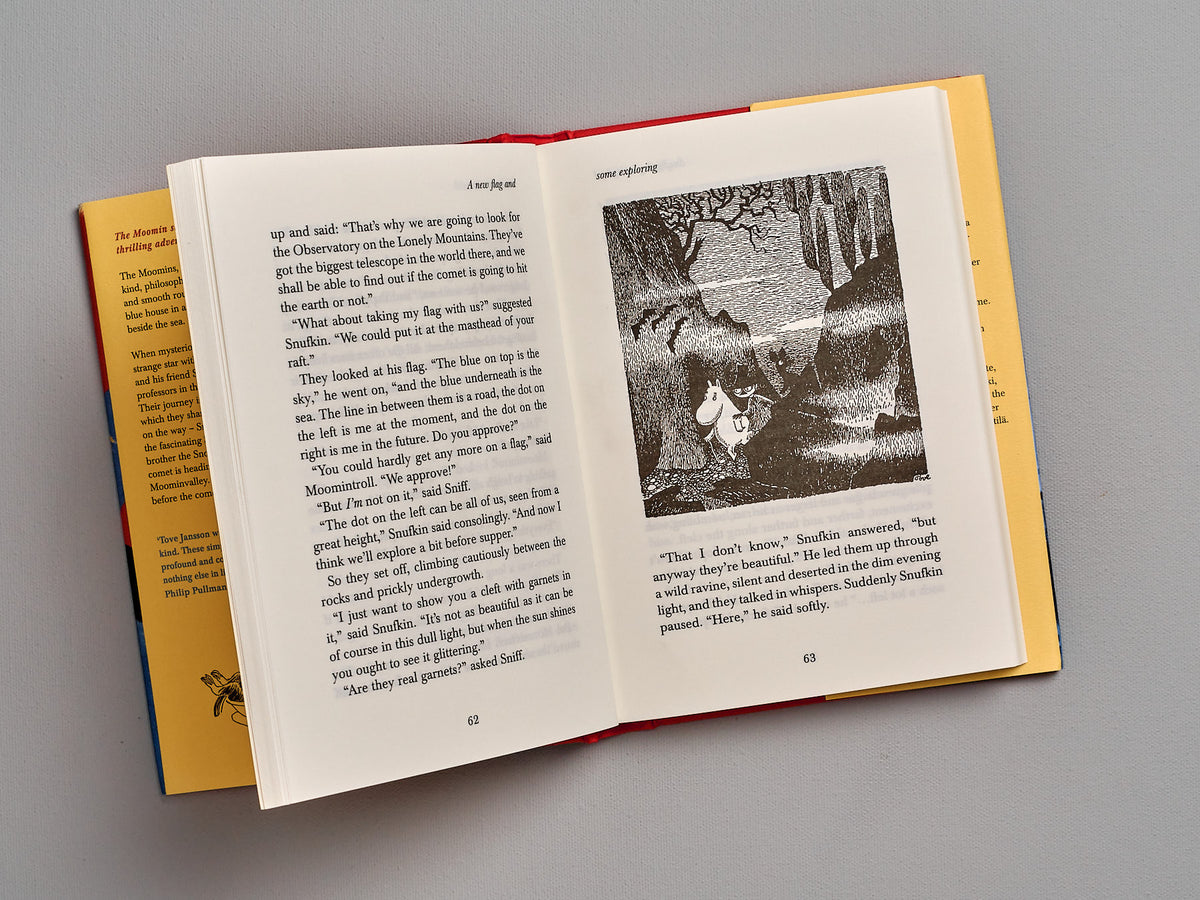 An open book with a picture of Comet in Moominland by Tove Jansson.