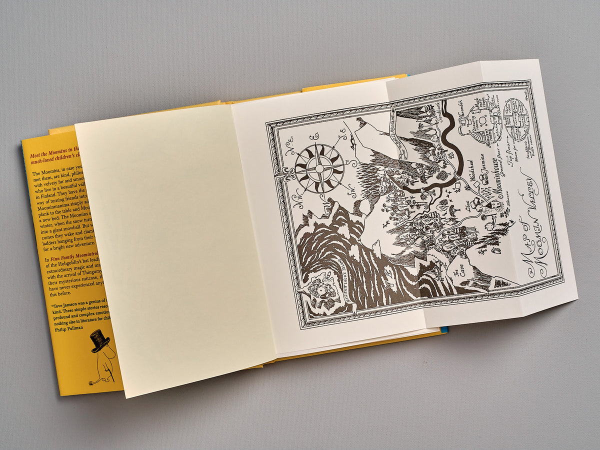 An open book of Finn Family Moomintroll by Tove Jansson with a drawing on it.