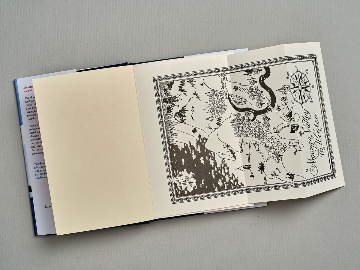 An open Moominland Midwinter book with a drawing on it by Tove Jansson.
