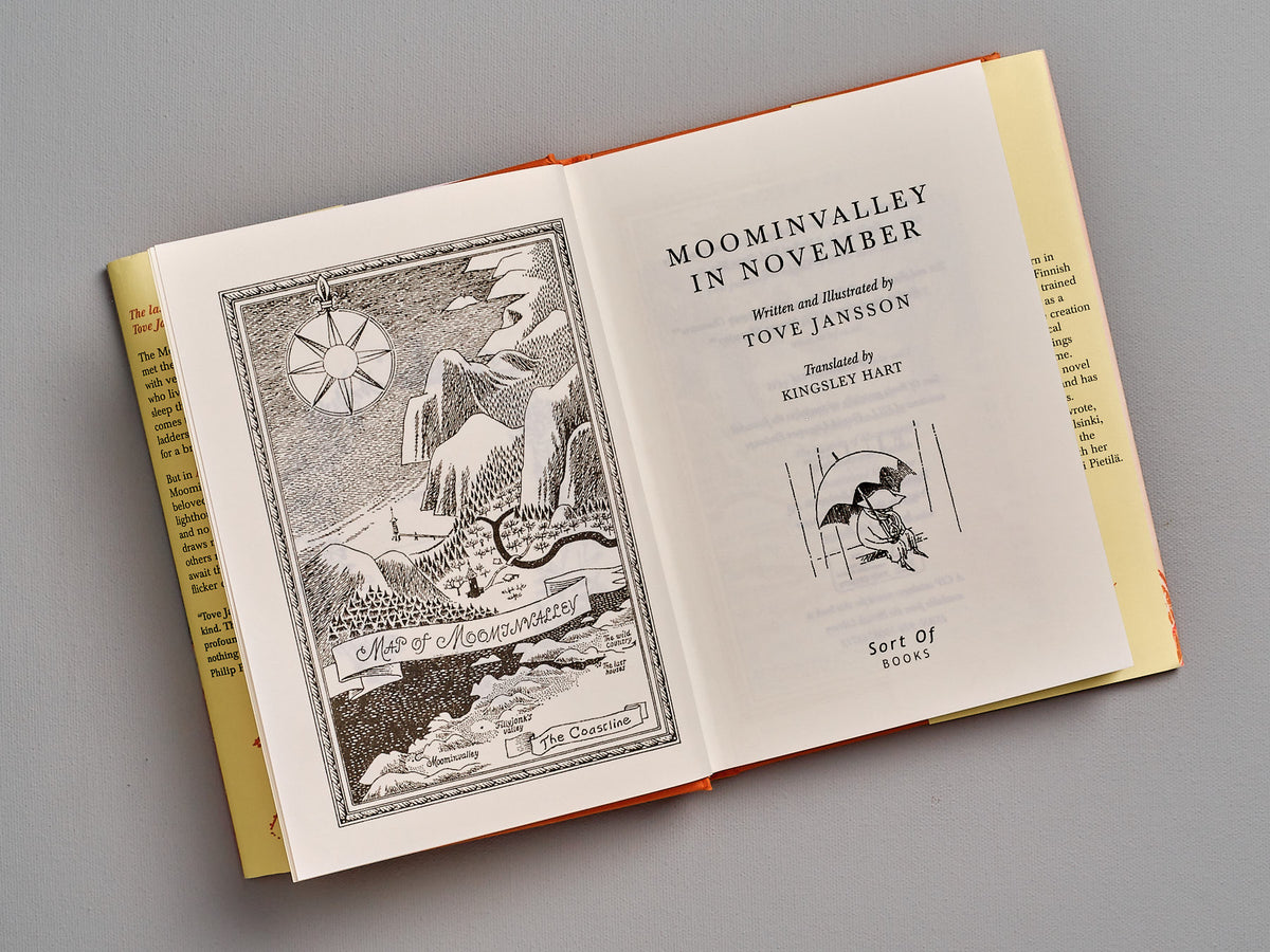 An open book with an illustration of Moominvalley in november by Tove Jansson.