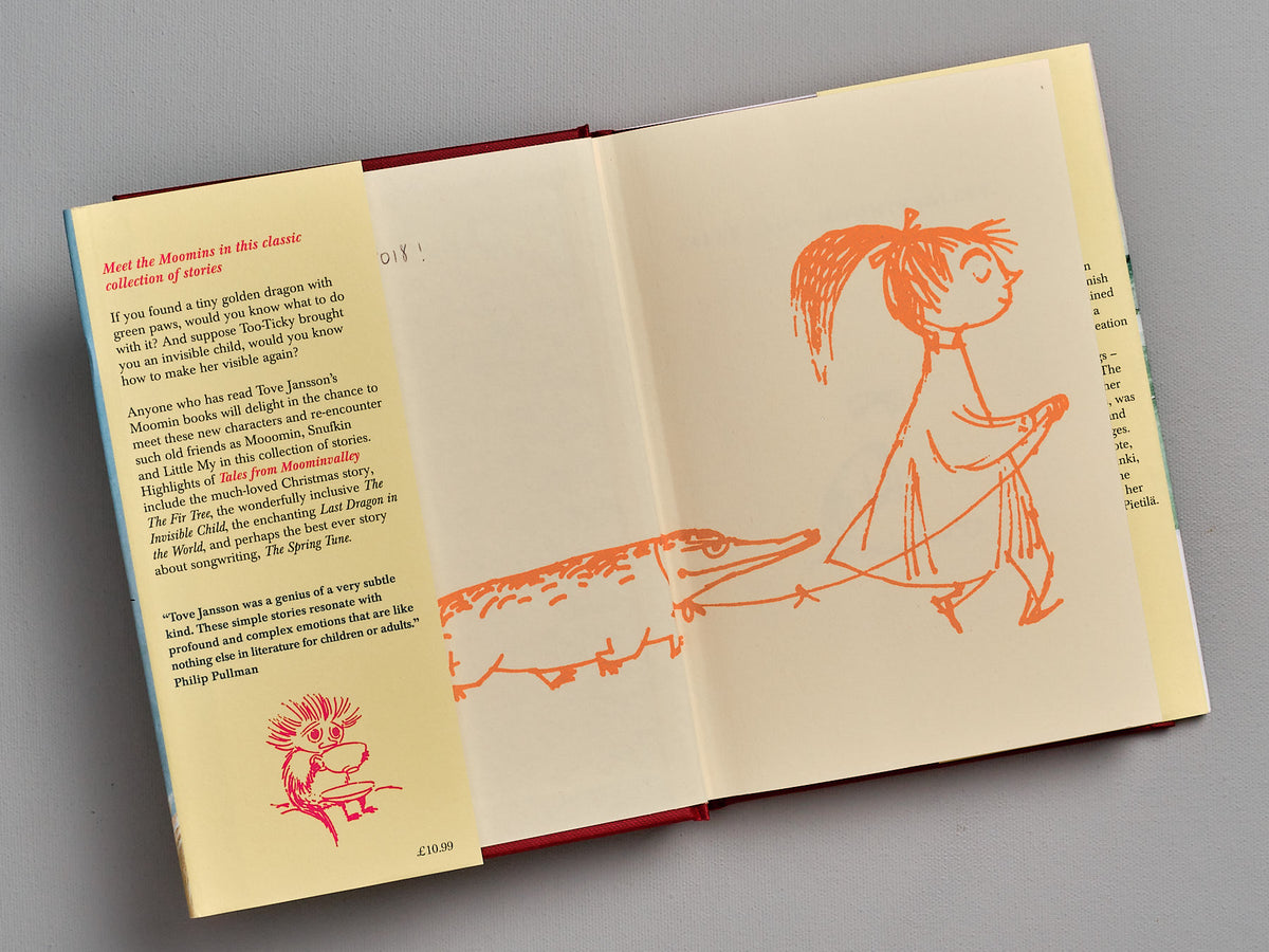 An open book with illustrations of a girl and a dog, Tales From Moominvalley by Tove Jansson.