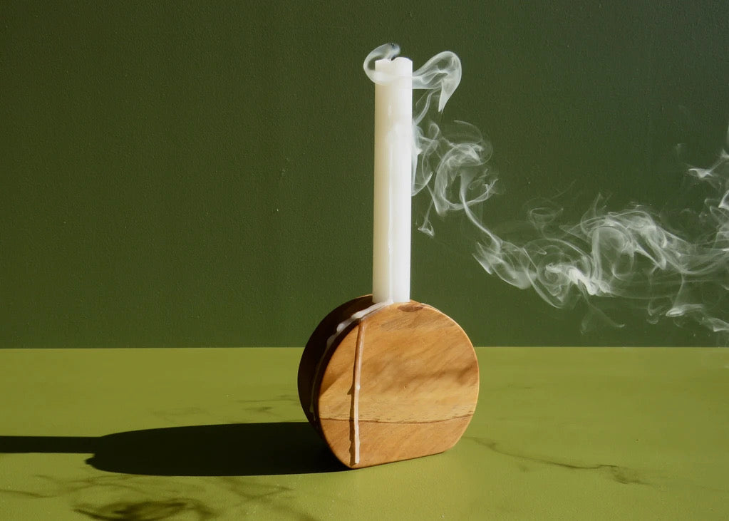 A wooden Orb Candle Holder with smoke coming out of it, made by The River.