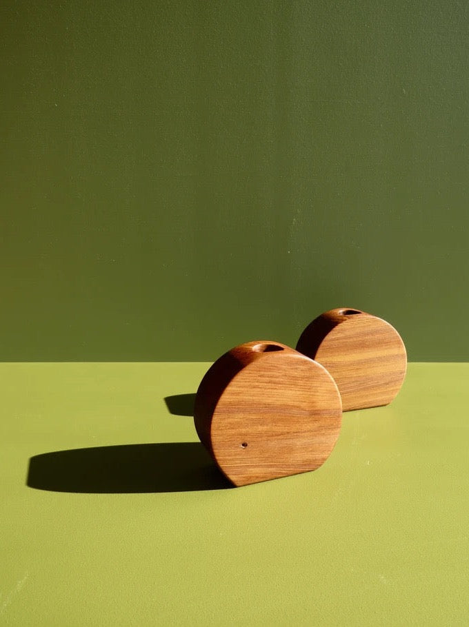 Two River Orb Candle Holders on a green surface.
