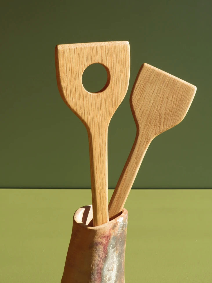 Two The River servers in a vase on a green table.