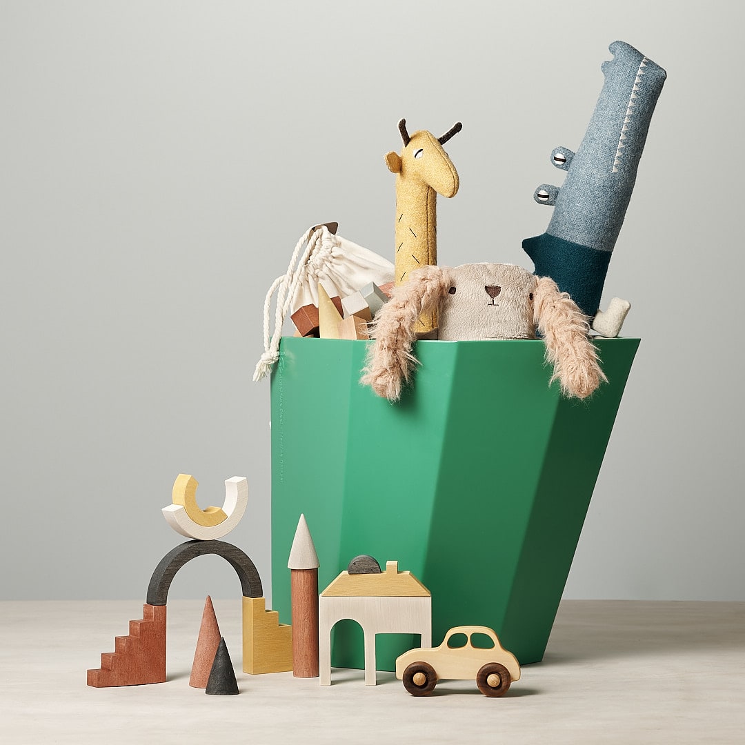 An Arnoldino Stool – Bright Green by Martino Gamper filled with toys and a giraffe.