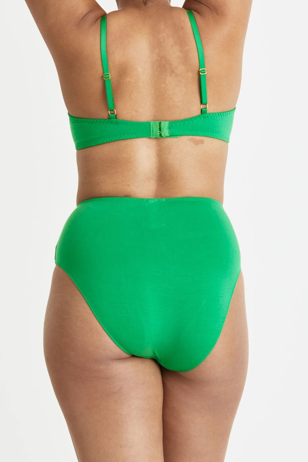The back view of a woman in a green Angela Bra – Poise bikini by Videris.