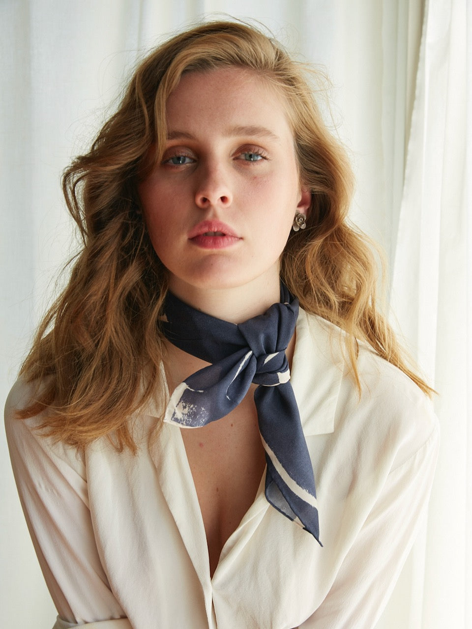 A young woman wearing a white shirt and an Amy Silk Necktie by Walker & Bing.