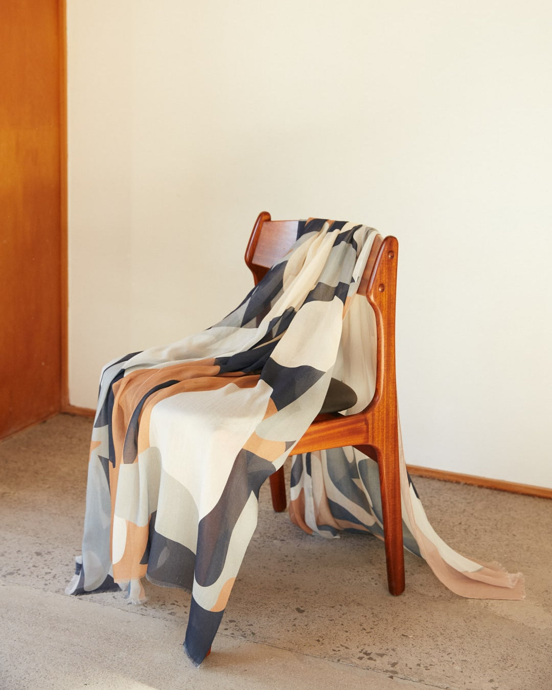 A Walker & Bing Rosemary Scarf in a room with a blanket on it.