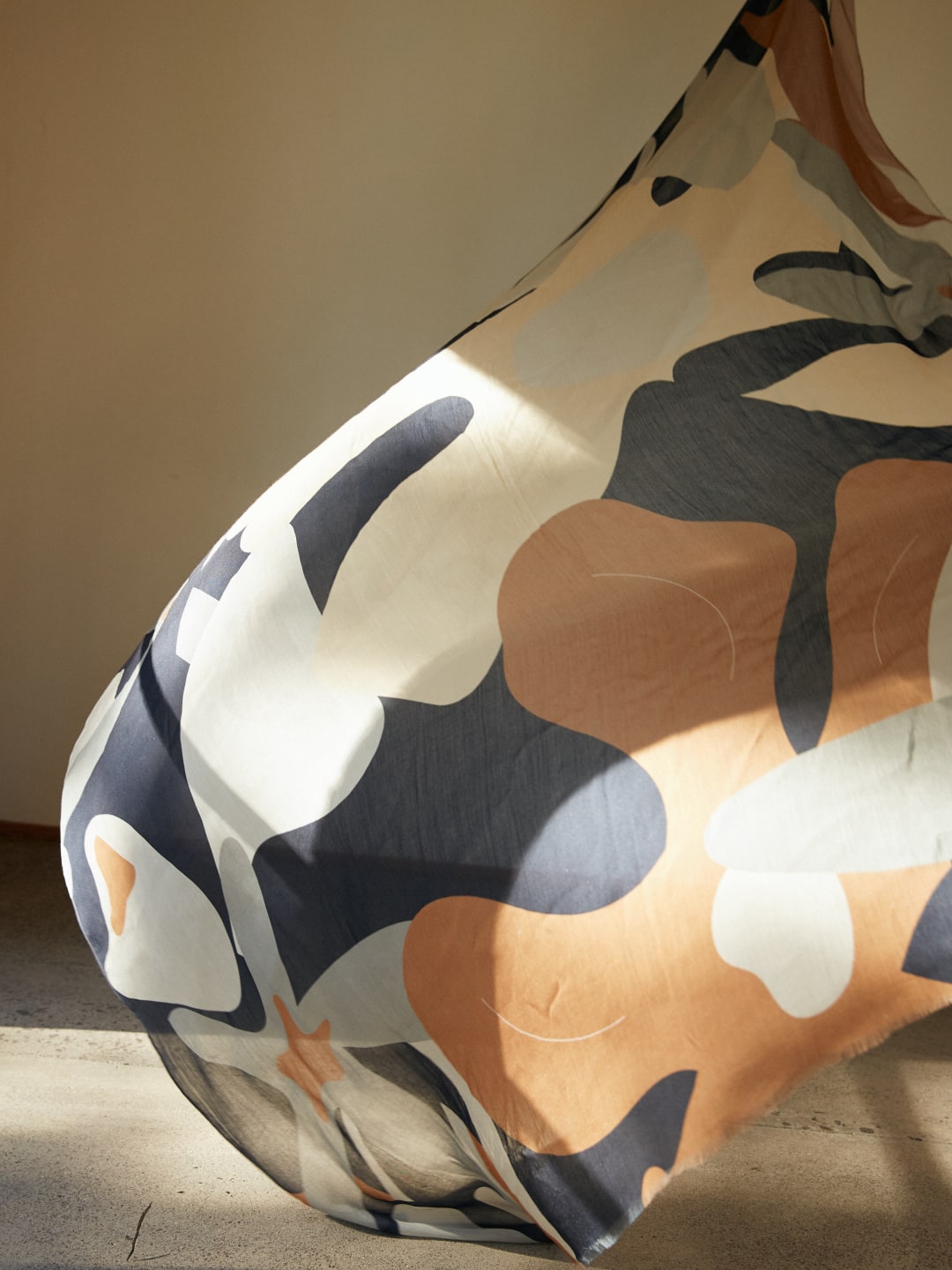 A large piece of Rosemary Scarf fabric hanging in a room by Walker & Bing.