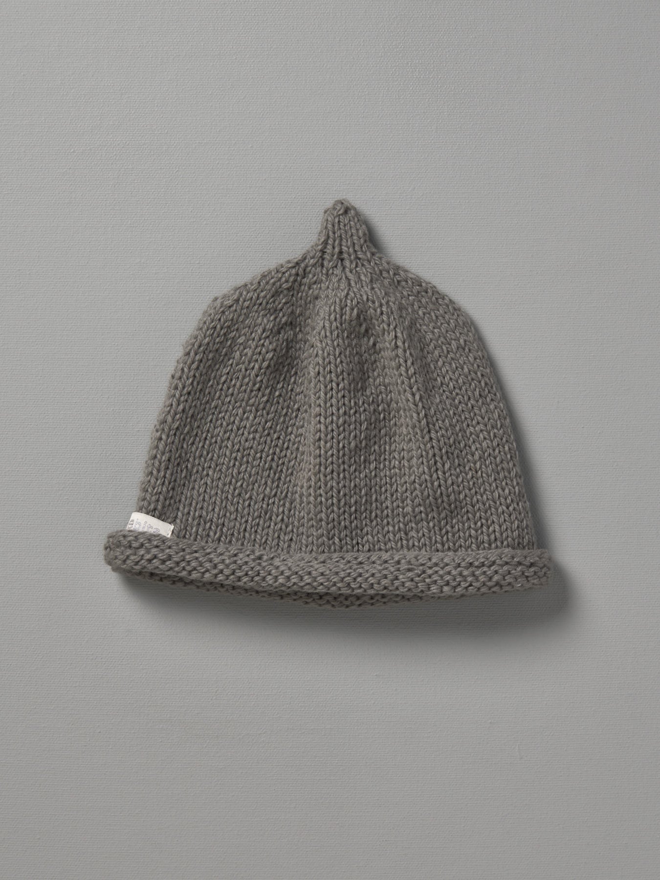 A Hand Knitted Baby Beanie - Mushroom by Weebits on a grey background.