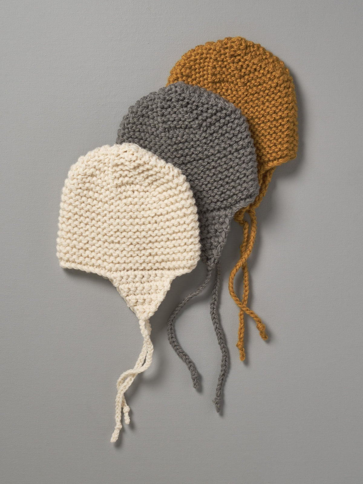 Three Hand Knitted Chunky Knit Hats - Mustard by Weebits on a grey background.