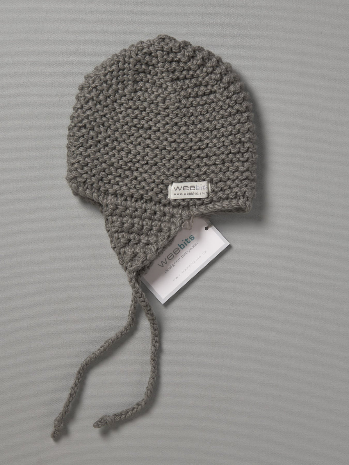 A grey Hand Knitted Chunky Knit Hat - Mushroom with a tag on it.