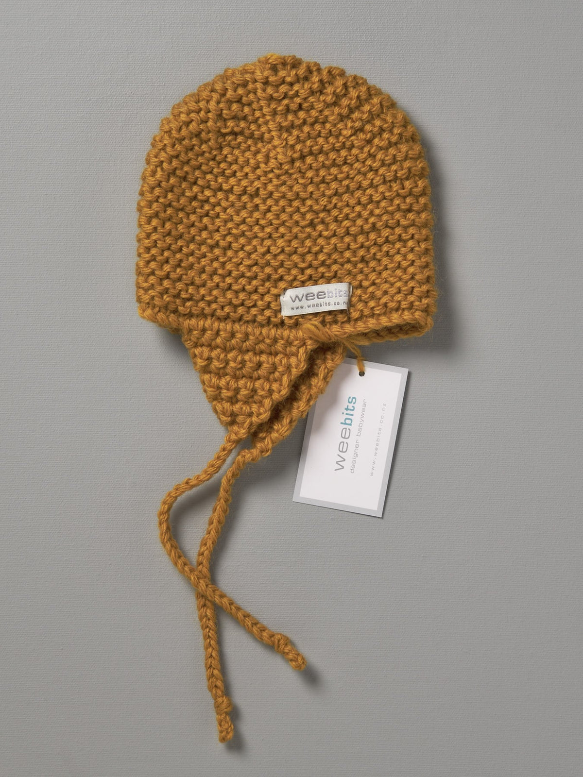 A Weebits Hand Knitted Chunky Knit Hat - Mustard with a tag on it.