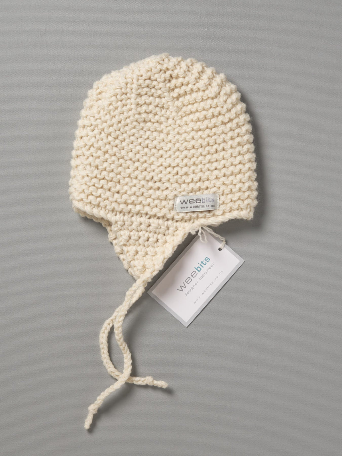 A white Hand Knitted Chunky Knit Hat - Natural with a tag on it. Brand Name: Weebits