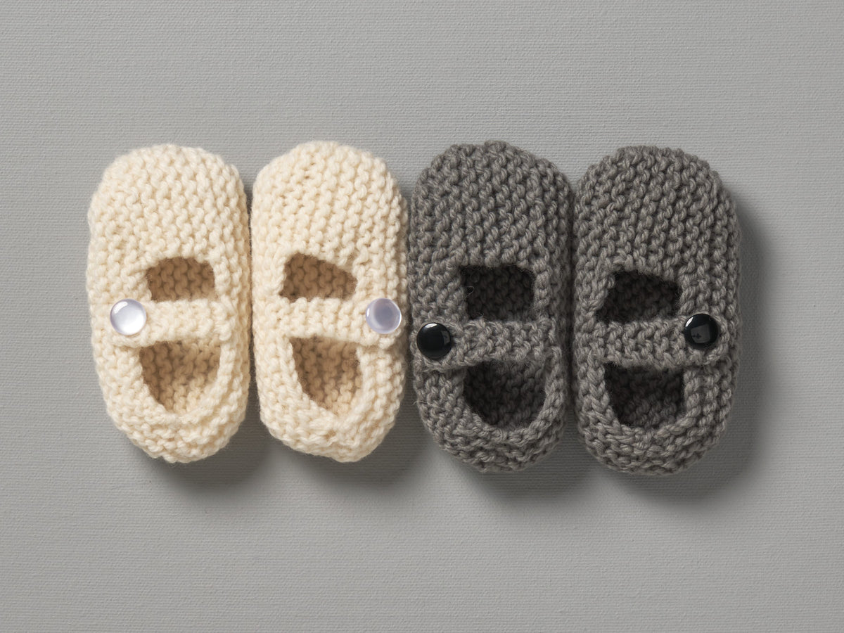 Three pairs of Weebits Hand Knitted Mary Jane Shoes - Mushroom on a grey surface.