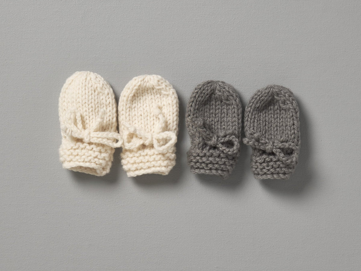 Three pairs of Weebits Hand Knitted Mushroom Mittens on a gray surface.