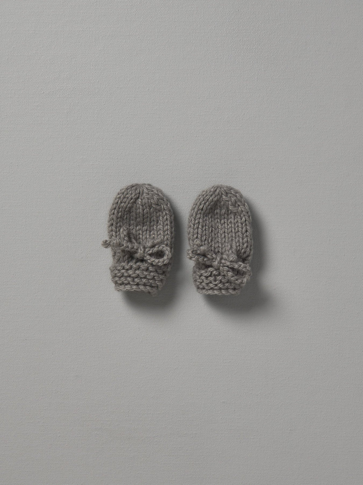 Two Weebits Mushroom hand knitted mittens on a white surface.