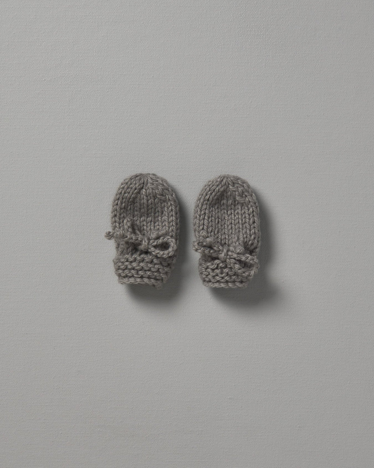 Two Weebits Mushroom hand knitted mittens on a white surface.