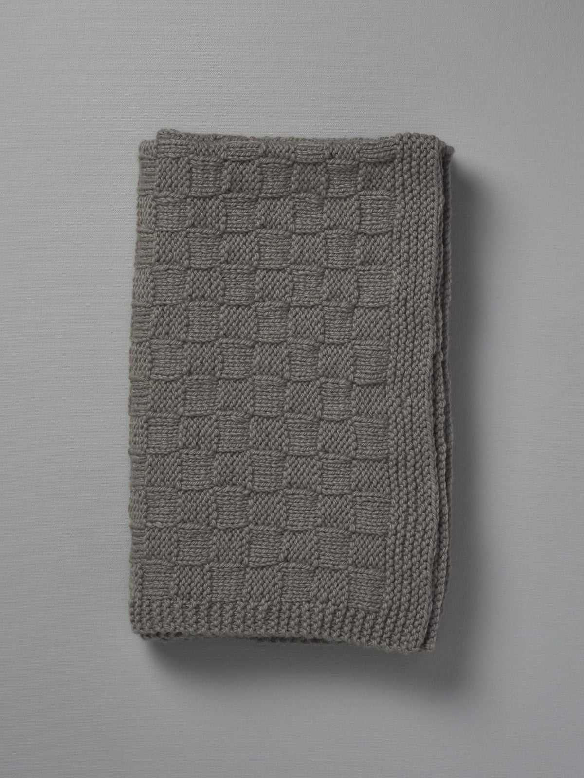 A Weebits Hand Knitted Travel Rug - Mushroom on a white background.