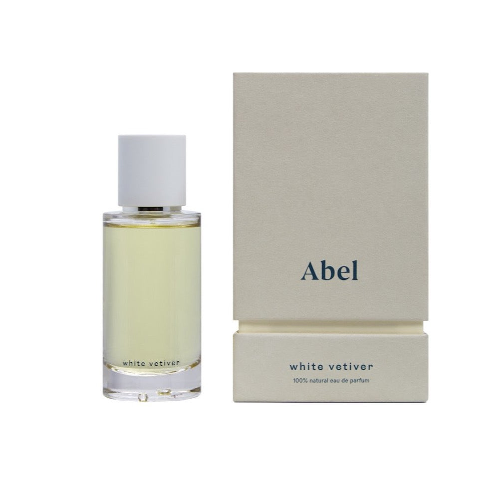 A bottle of White Vetiver - a zesty, cool wood fragrance from Abel next to its packaging.