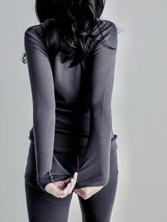 A woman posing with her hands on her hips wearing a Ruru Merino Rib Crew - Charcoal by YARN nz.