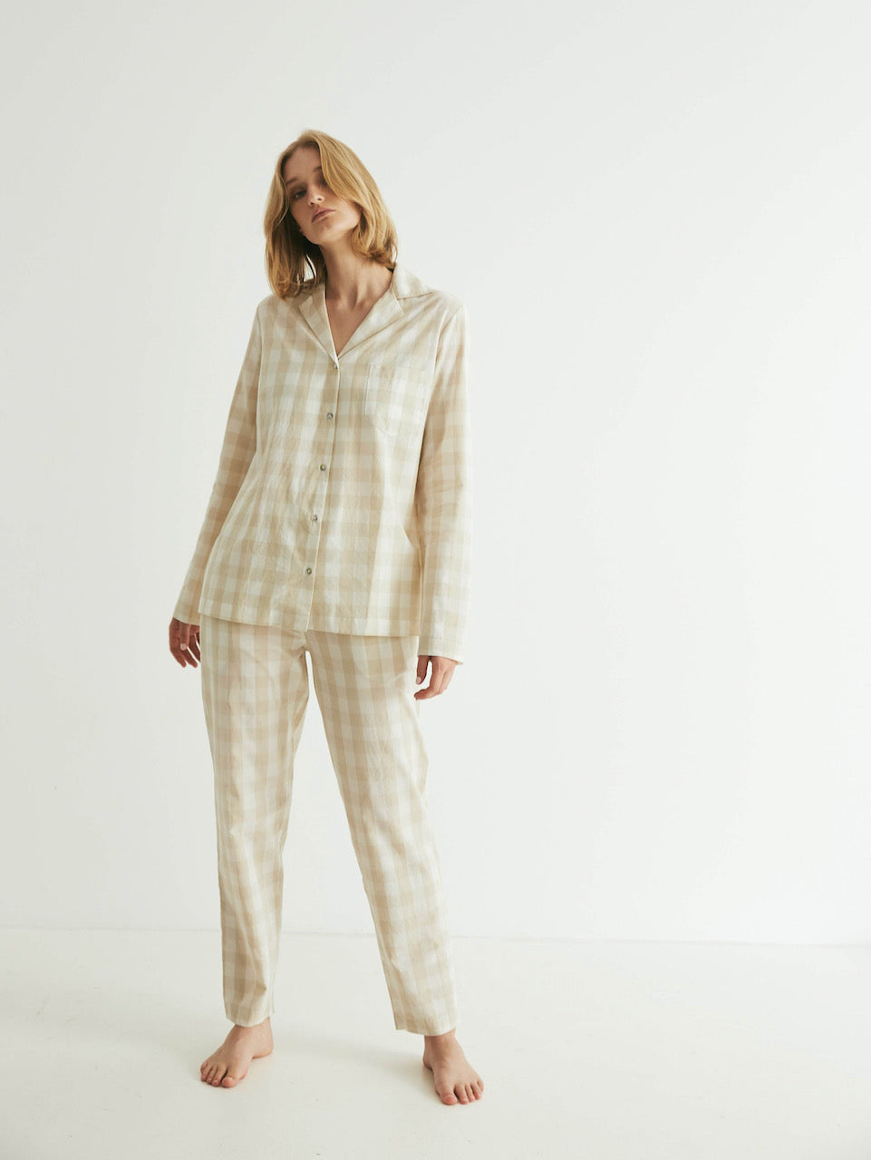 A woman wearing a beige plaid pyjama set.
Product: Classic Set - Oatmeal Gingham
Brand: general sleep