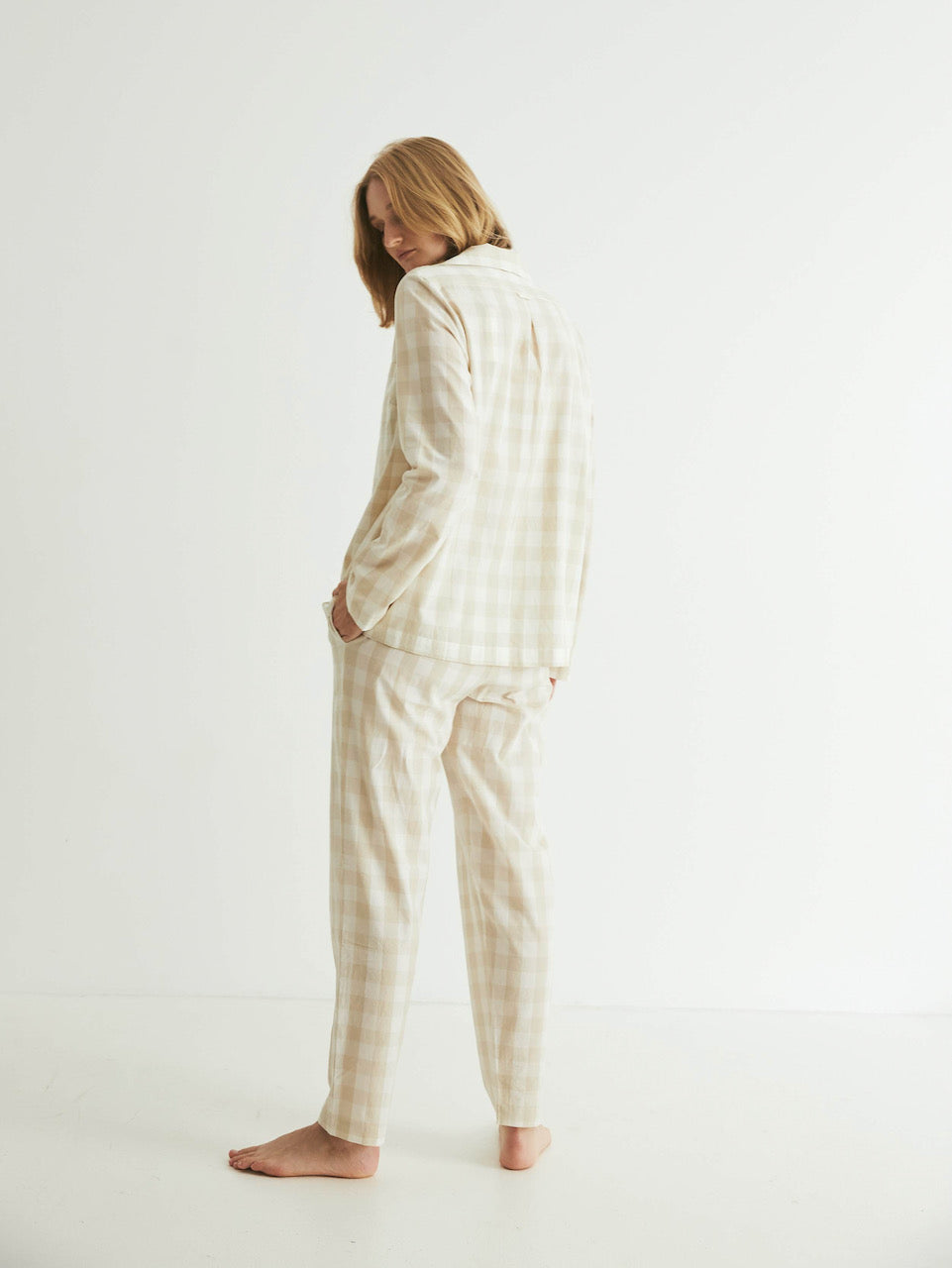 A woman wearing a &quot;Classic Set - Oatmeal Gingham&quot; pajama set by general sleep.