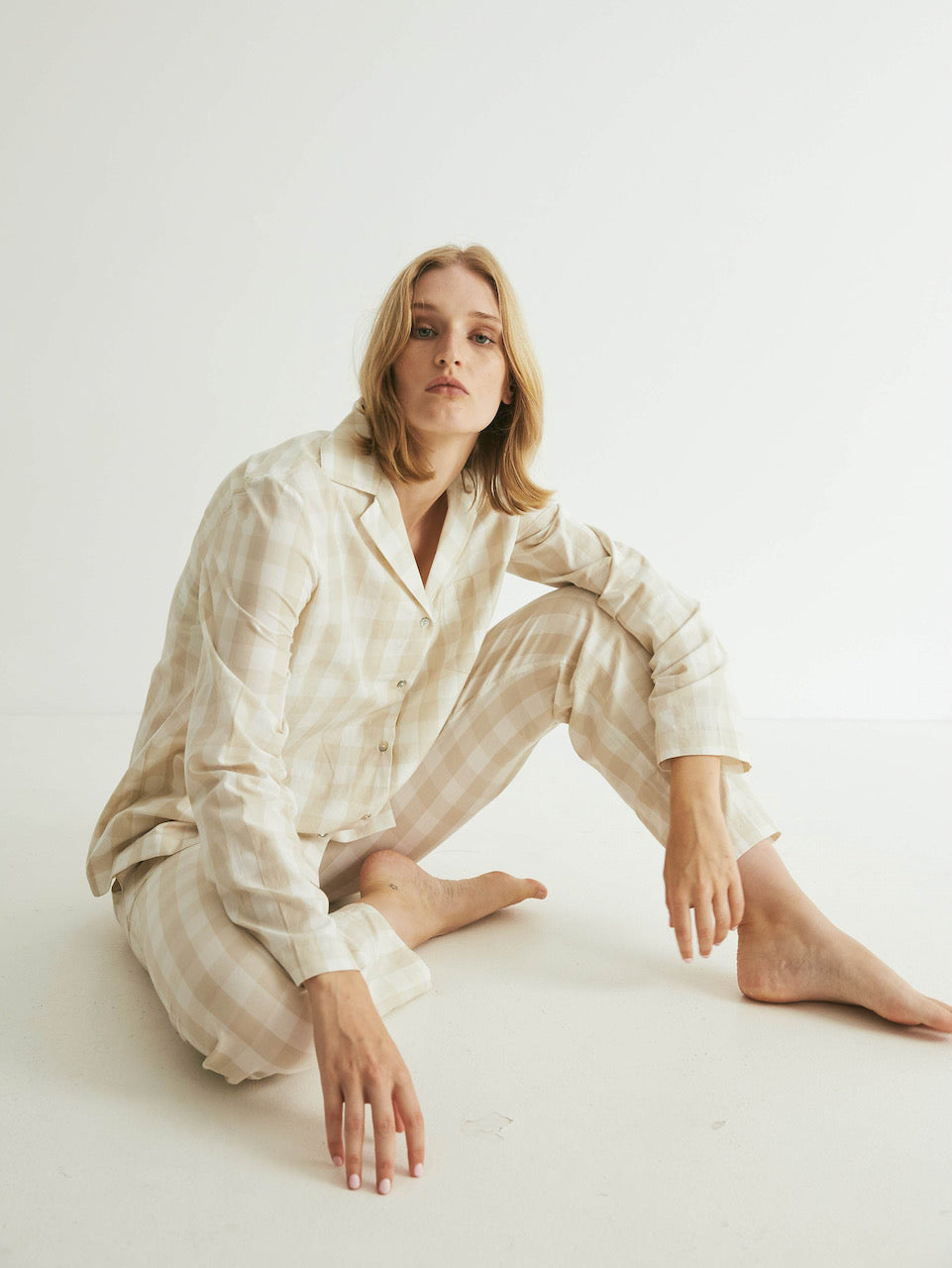 A woman sitting on the floor in a Oatmeal Gingham Classic Set by general sleep.