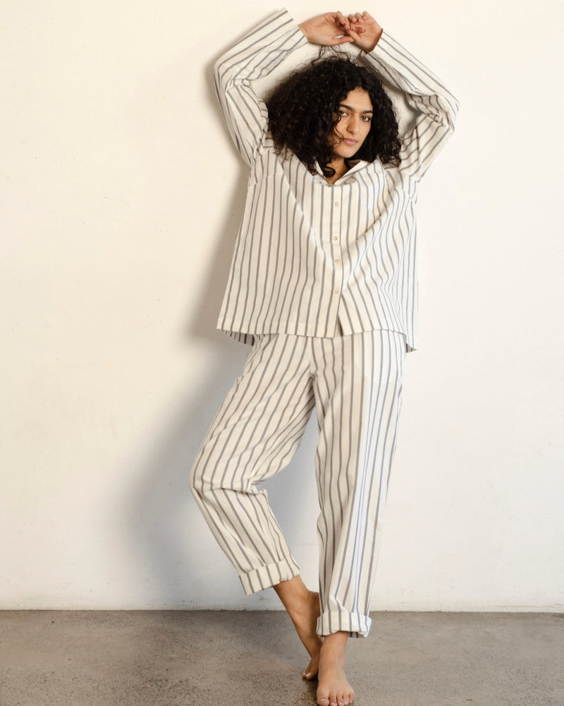 A woman wearing a general sleep Classic Set - Stripe pajama set.