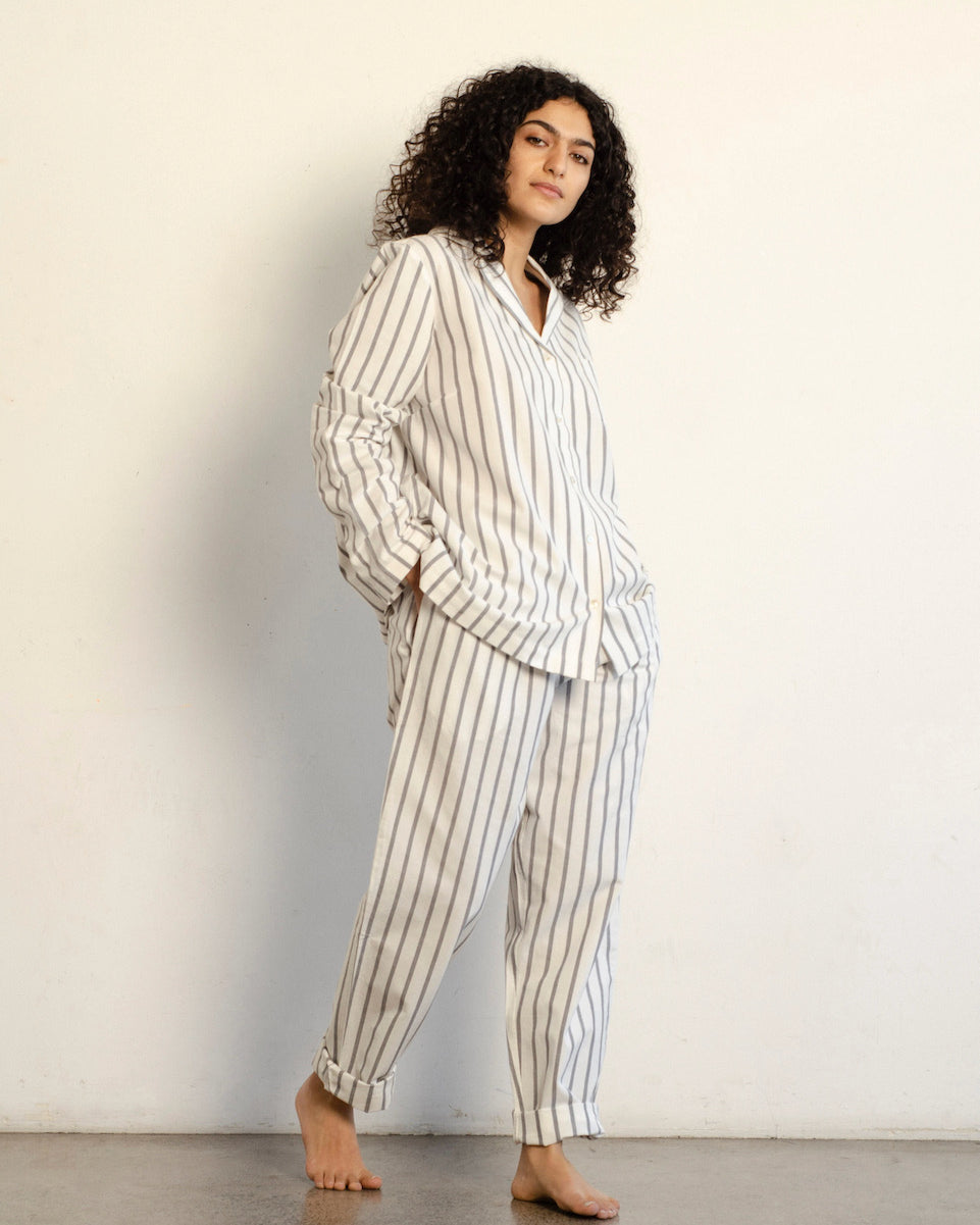 A woman wearing a white and black striped Classic Set - Stripe pajama set by general sleep.