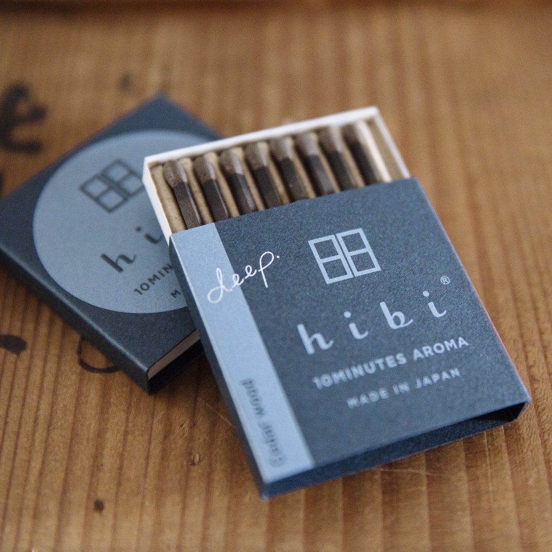 hibi match box incense deep – Cedar Wood matches in a box on top of a wooden table.