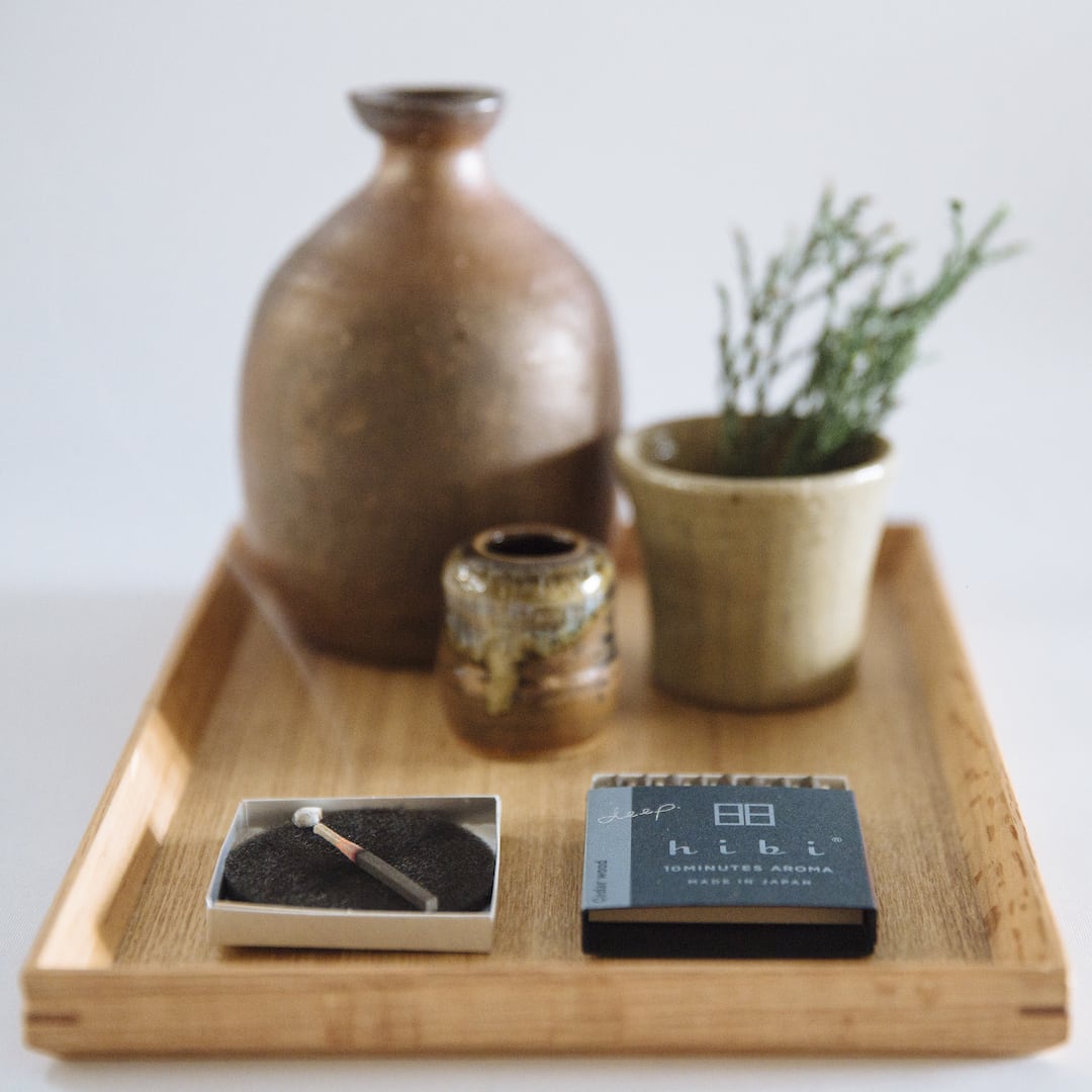 A hibi wooden tray with a hibi Match Box Incense Deep – Cedar Wood and a cigarette.
