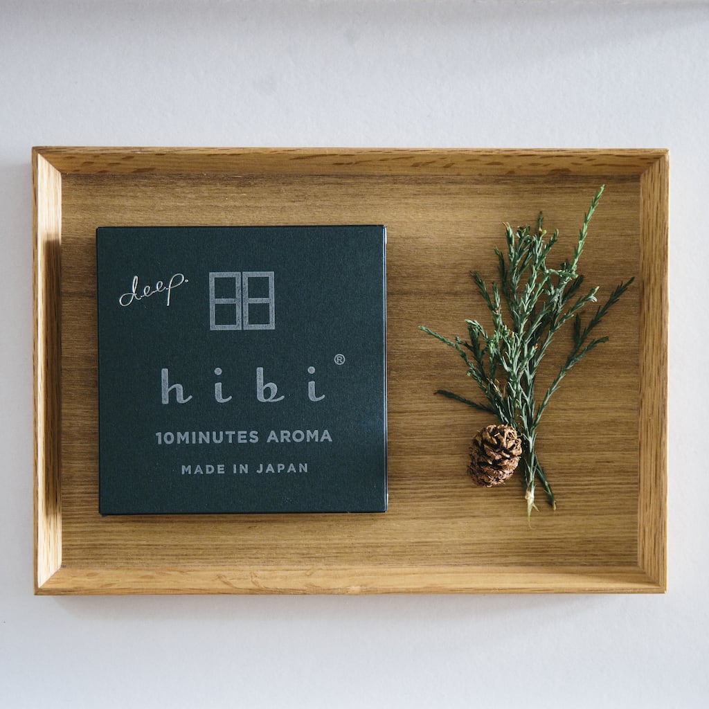 A hibi Deep Scent Gift Box with a candle and a pine cone on it.