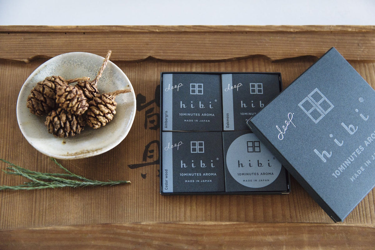 A hibi Match Box Incense – Deep Scent Gift Box with pine cones and a box of chocolates.