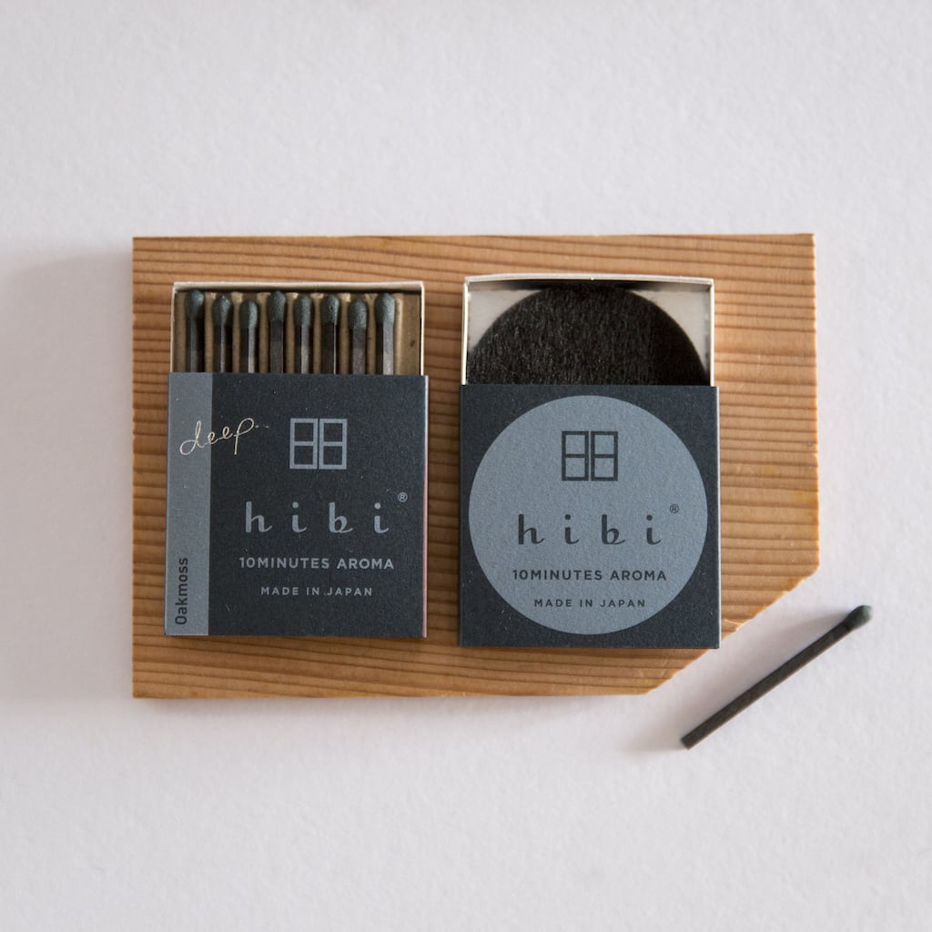A hibi Match Box Incense Deep – Oak Moss and a pencil on a wooden board.