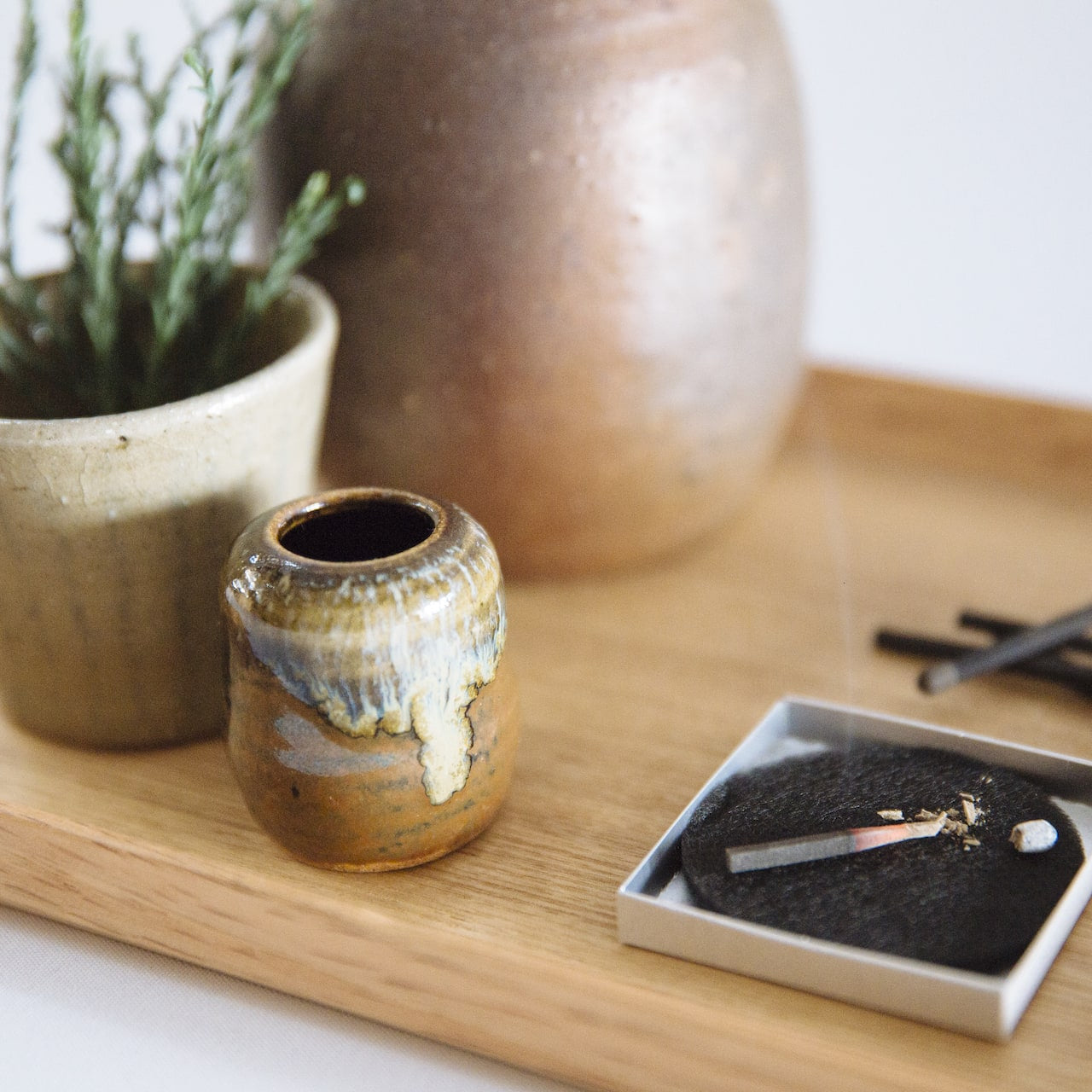 A hibi Match Box Incense Deep – Oak Moss and a pencil on a wooden board.