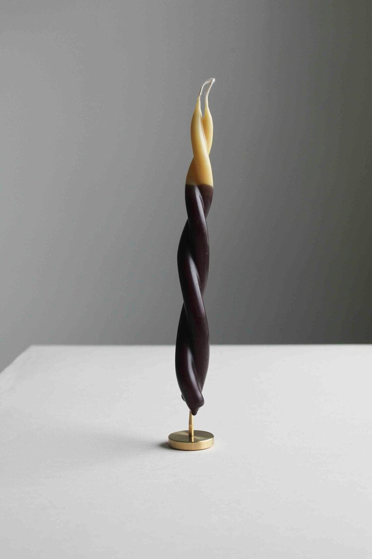 A Twisted Candle - Double-Dipped by Wax Atelier sitting on top of a table.