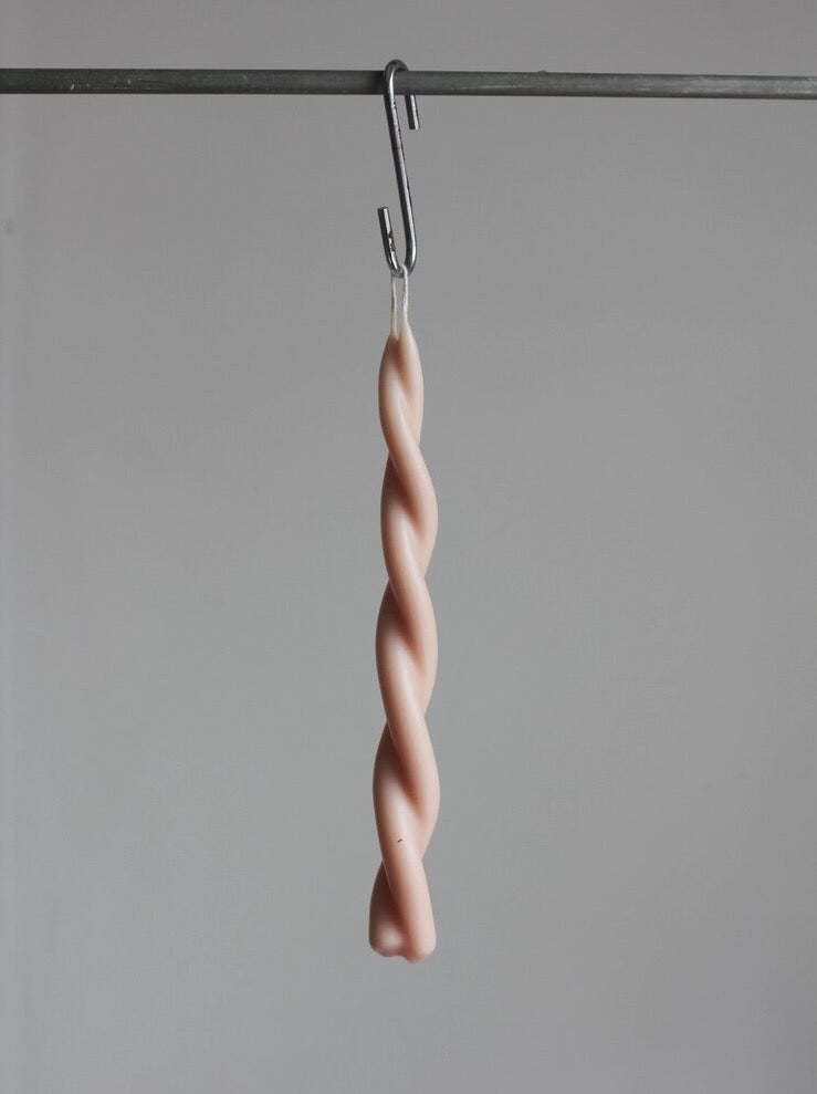 A Twisted Candle – Pink Blossom from Wax Atelier hanging from a hook.